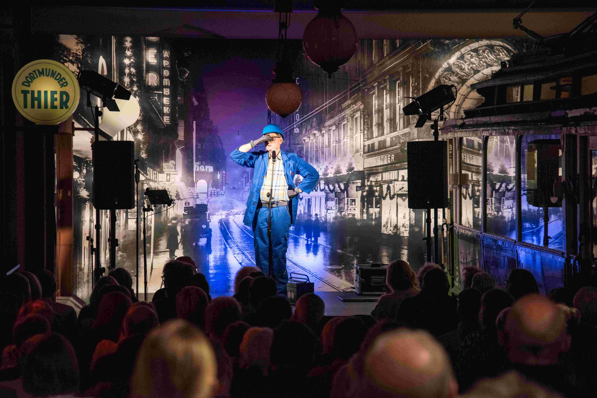 Handwerker Peters live auf der Comedy-Bühne hält sich die Hand vor den Kopf